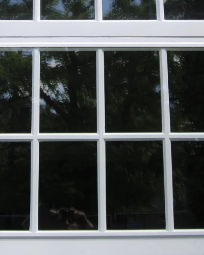 Exterior view of a white-framed grid window with WindowSLIP installed over the original panes.